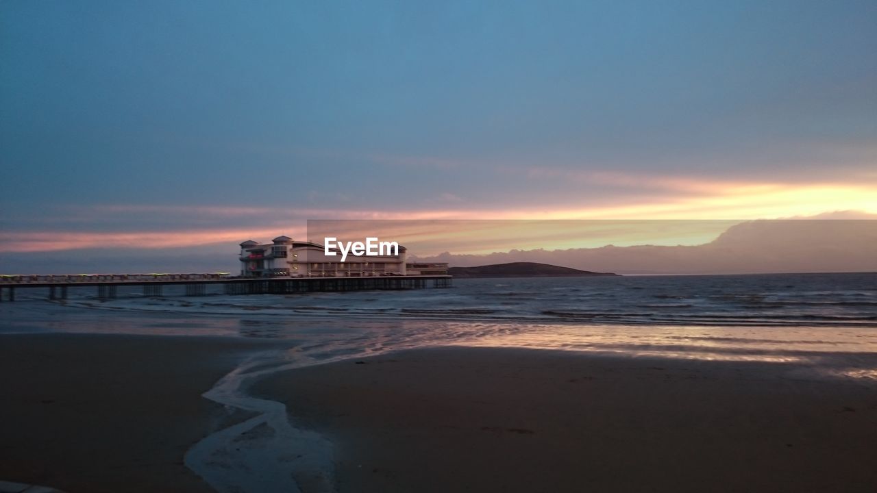 Scenic view of beach against sky during sunset