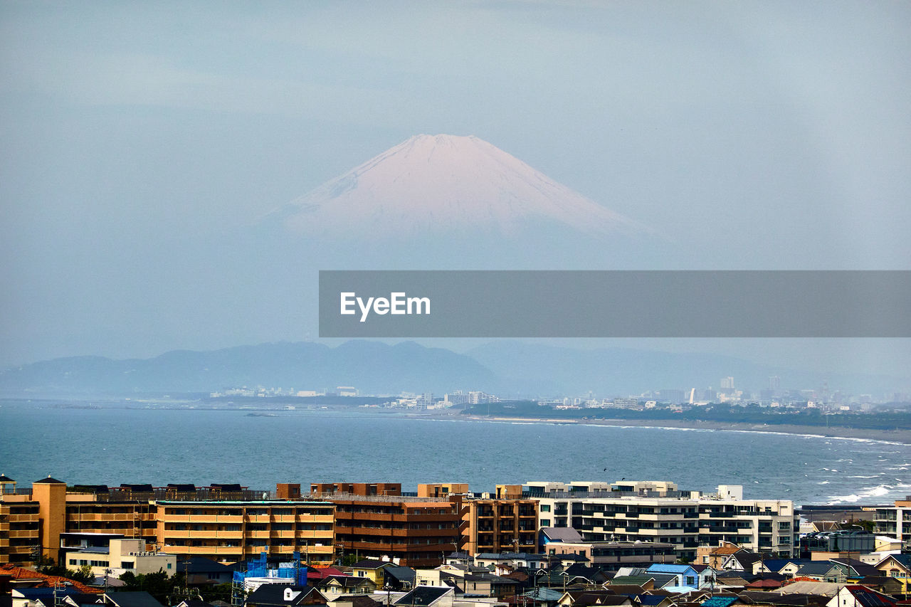 Aerial view of city against cloudy sky