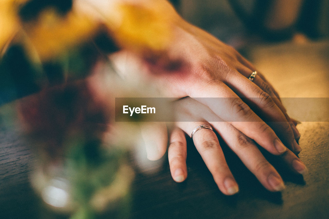 Cropped hand of man holding woman hand on table