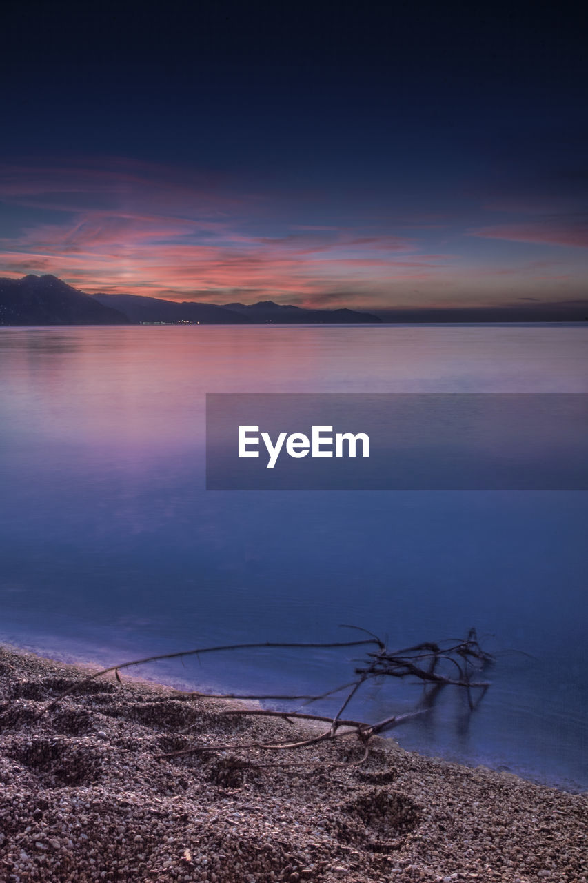 Scenic view of sea against dramatic sky during sunset