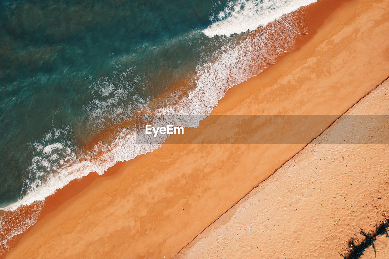 High angle view of sea waves on shore at beach