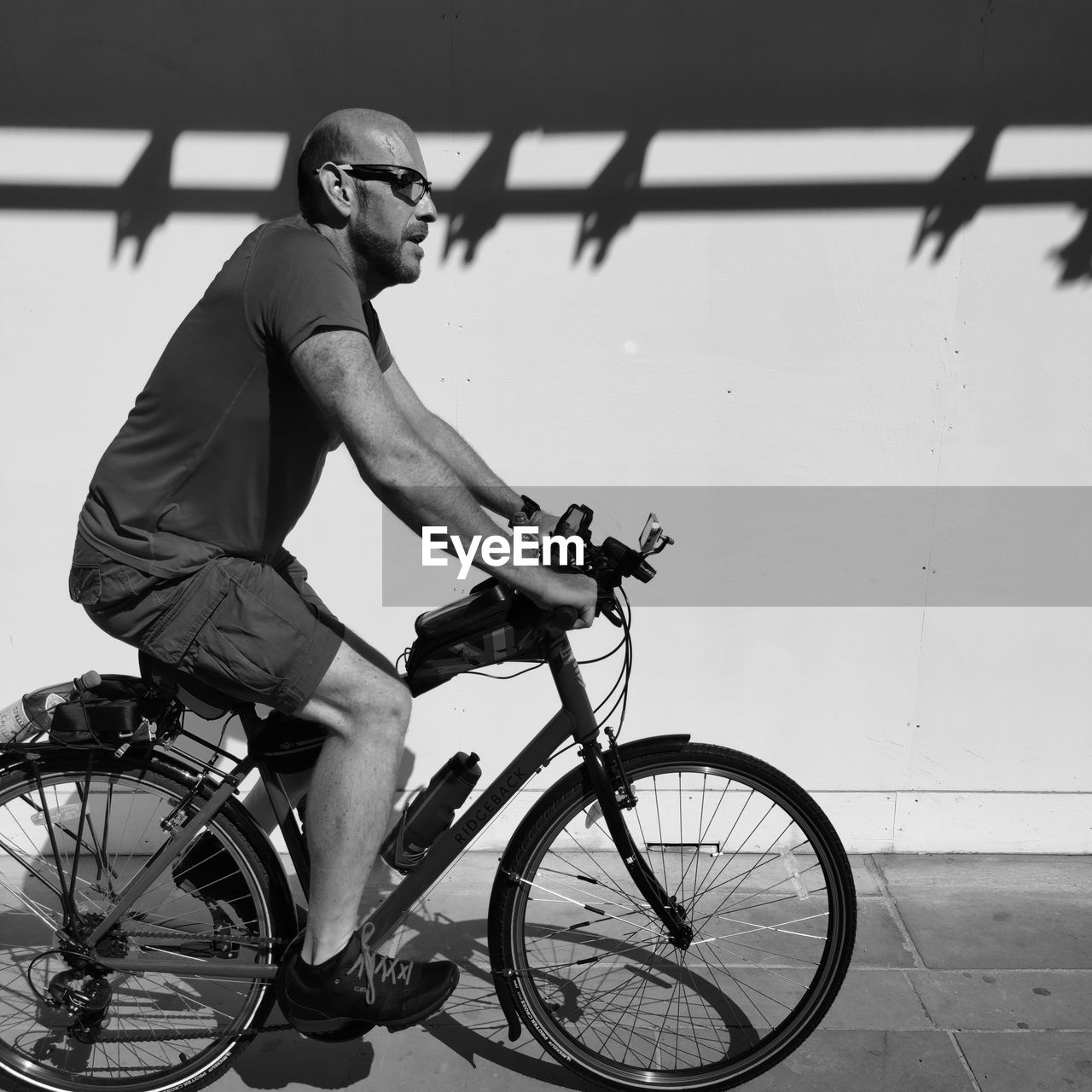 SIDE VIEW OF YOUNG MAN RIDING BICYCLE ON STREET