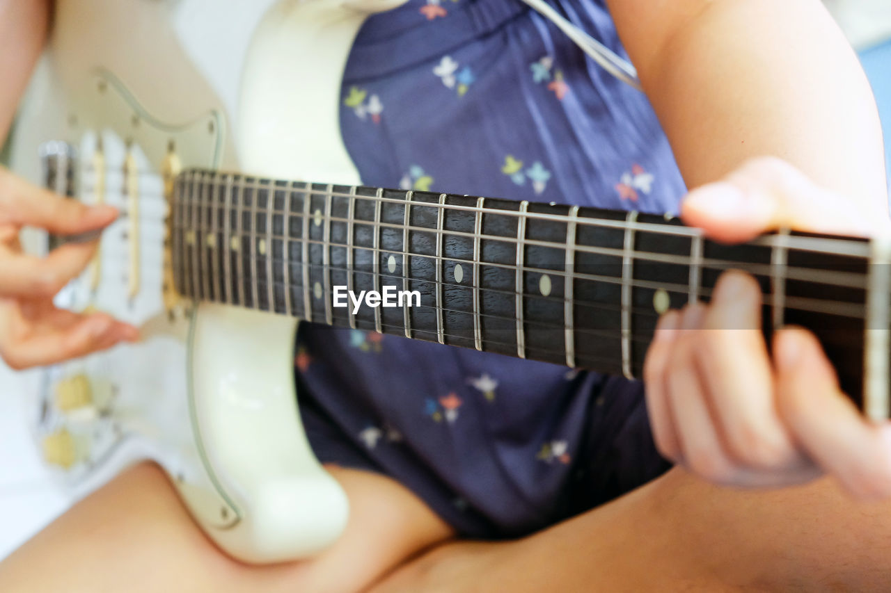 Midsection of women playing guitar