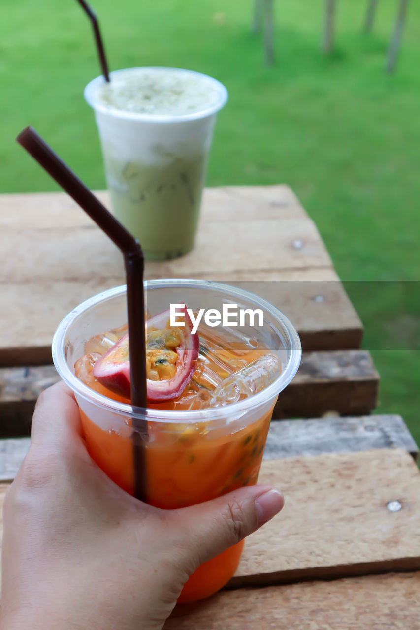 CLOSE-UP OF PERSON HOLDING GLASS OF DRINK