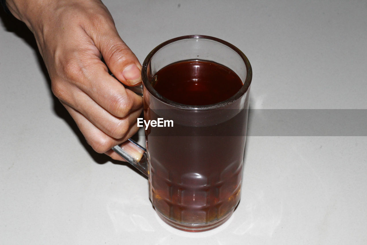 MIDSECTION OF MAN HOLDING COFFEE