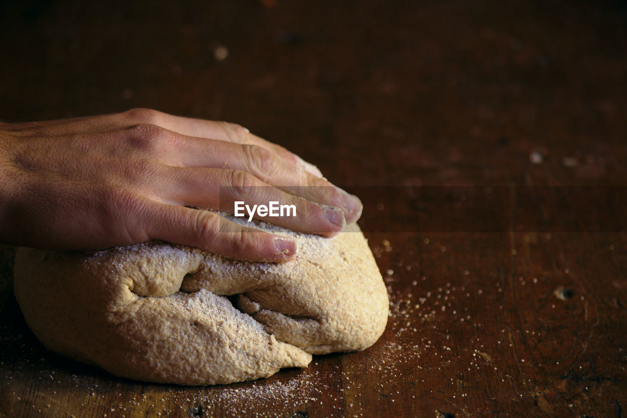 Cropped hand kneading dough