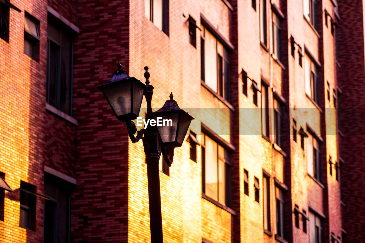 Low angle view of street light by buildings in city
