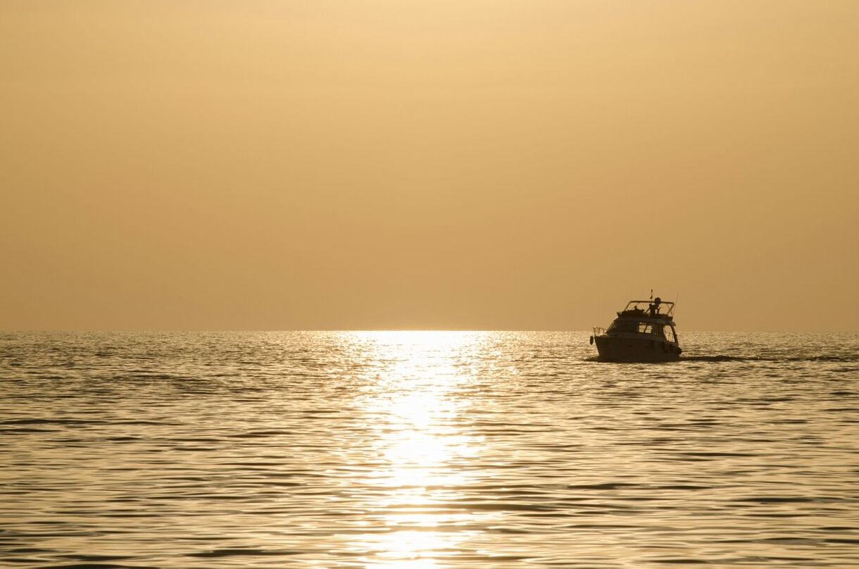 Yacht in sea at sunset