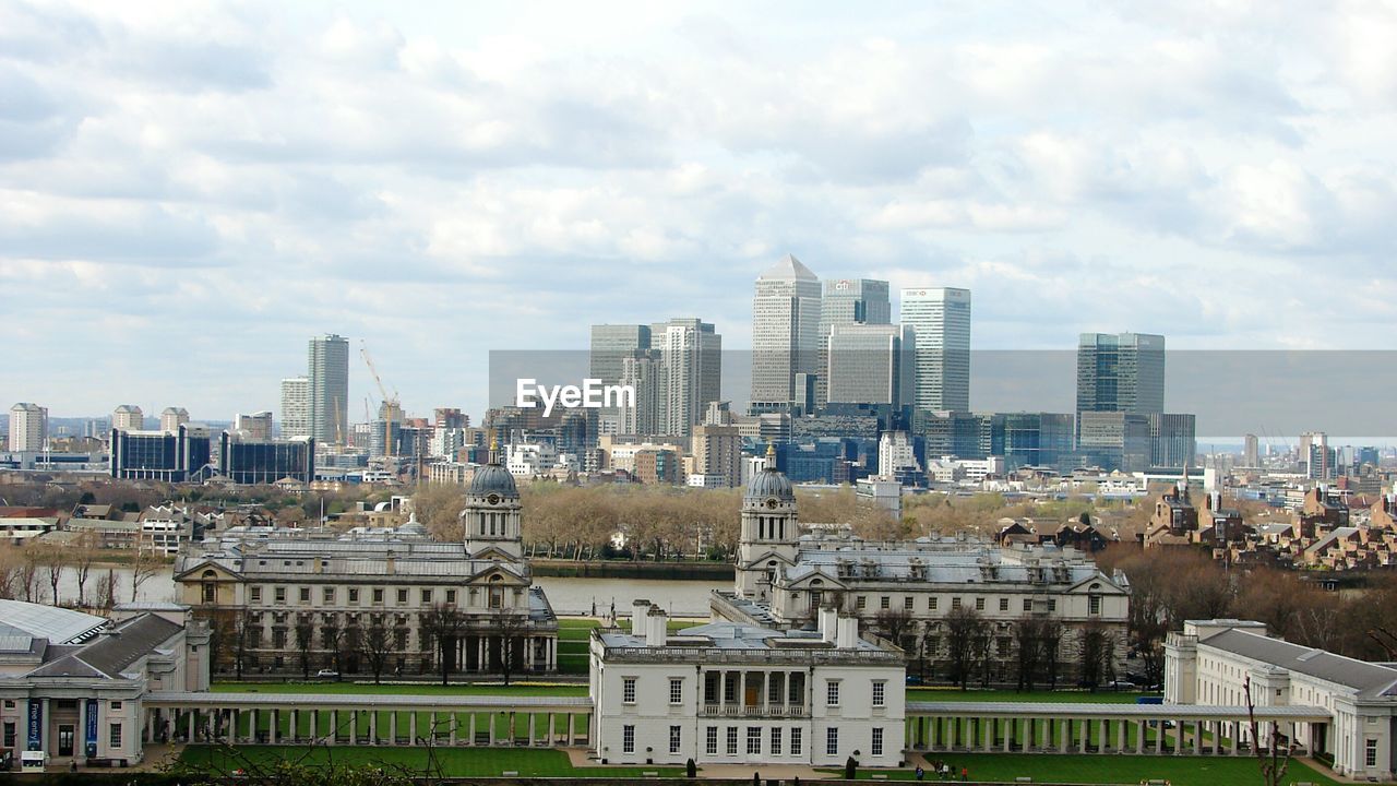 Royal navy college by cityscape against cloudy sky