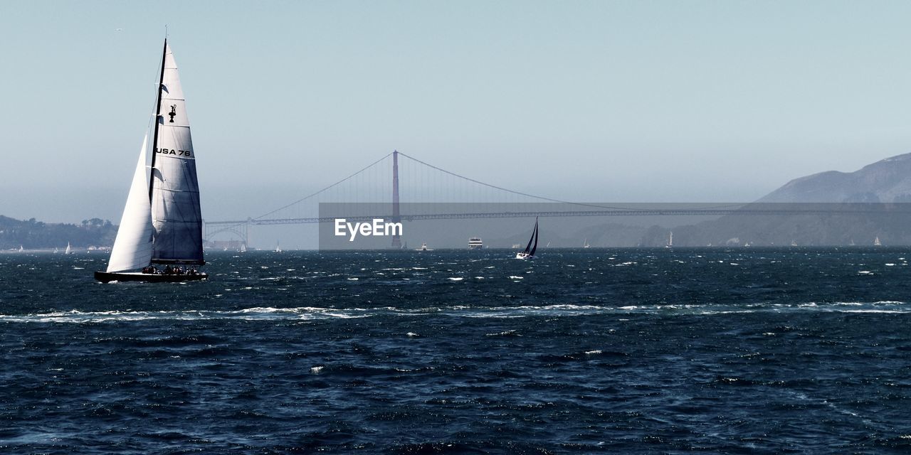 SCENIC VIEW OF SUSPENSION BRIDGE OVER SEA