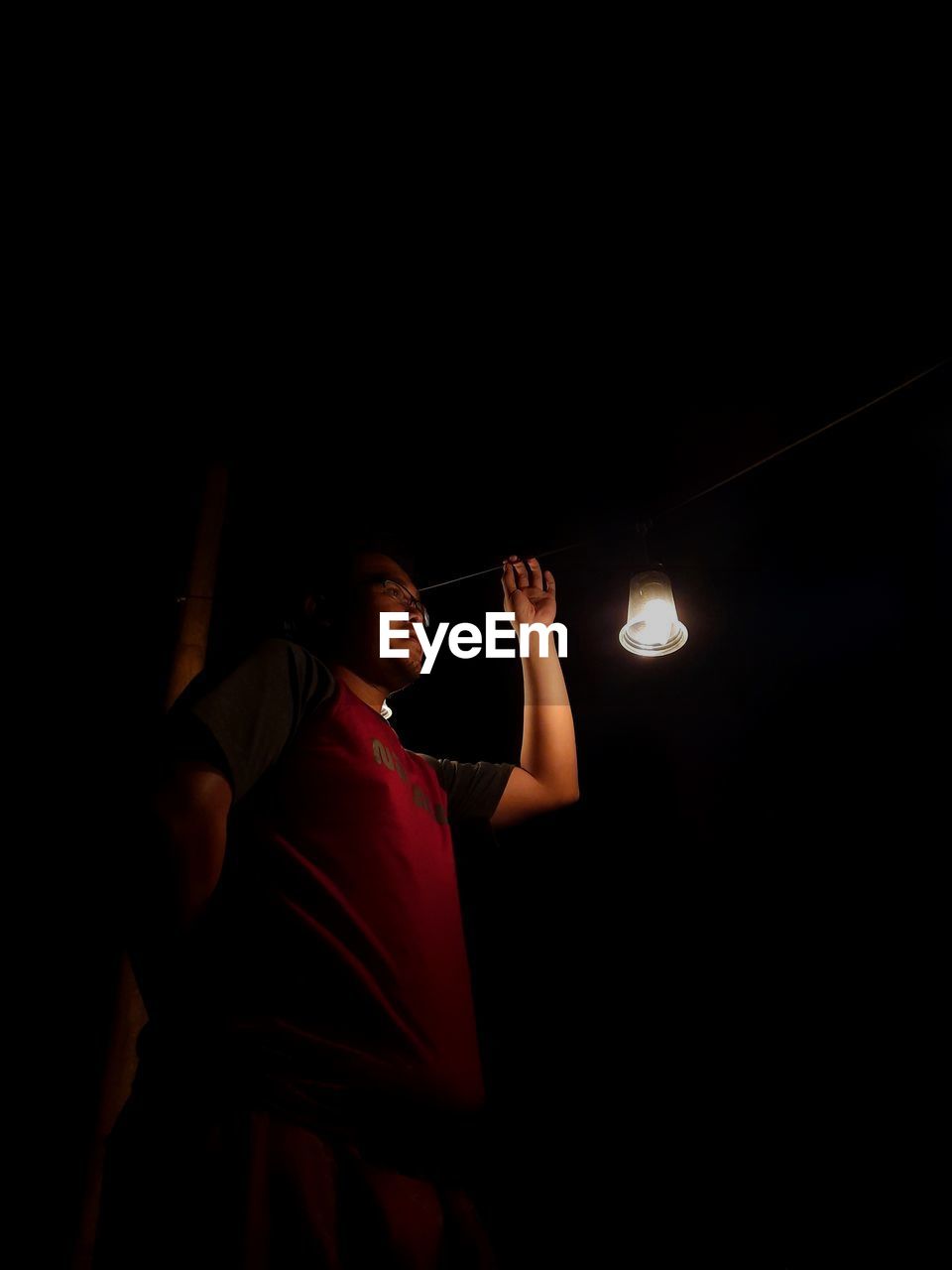 Low angle view of woman standing in illuminated dark