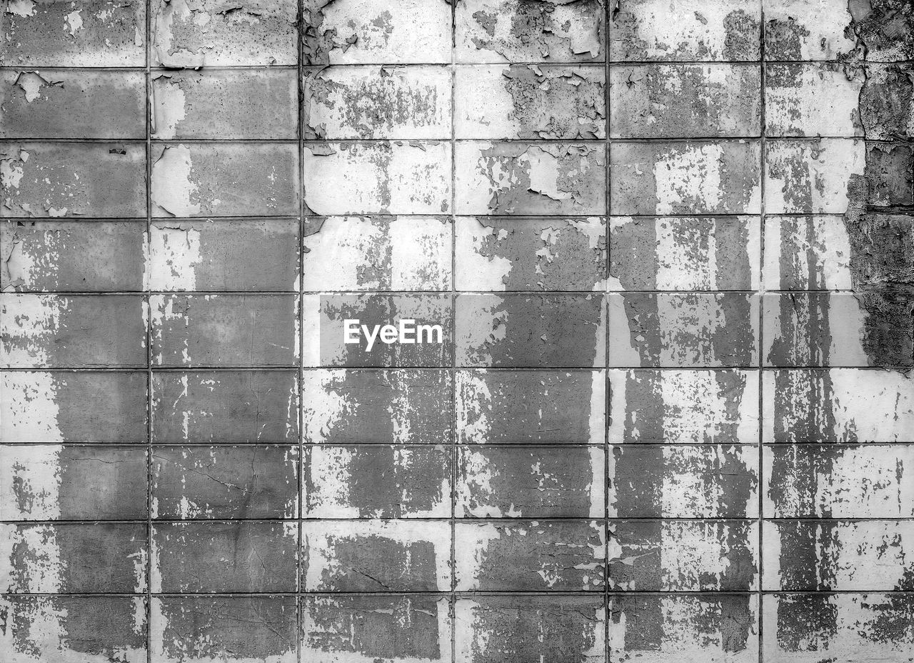 FULL FRAME SHOT OF WEATHERED WALL WITH SHADOW