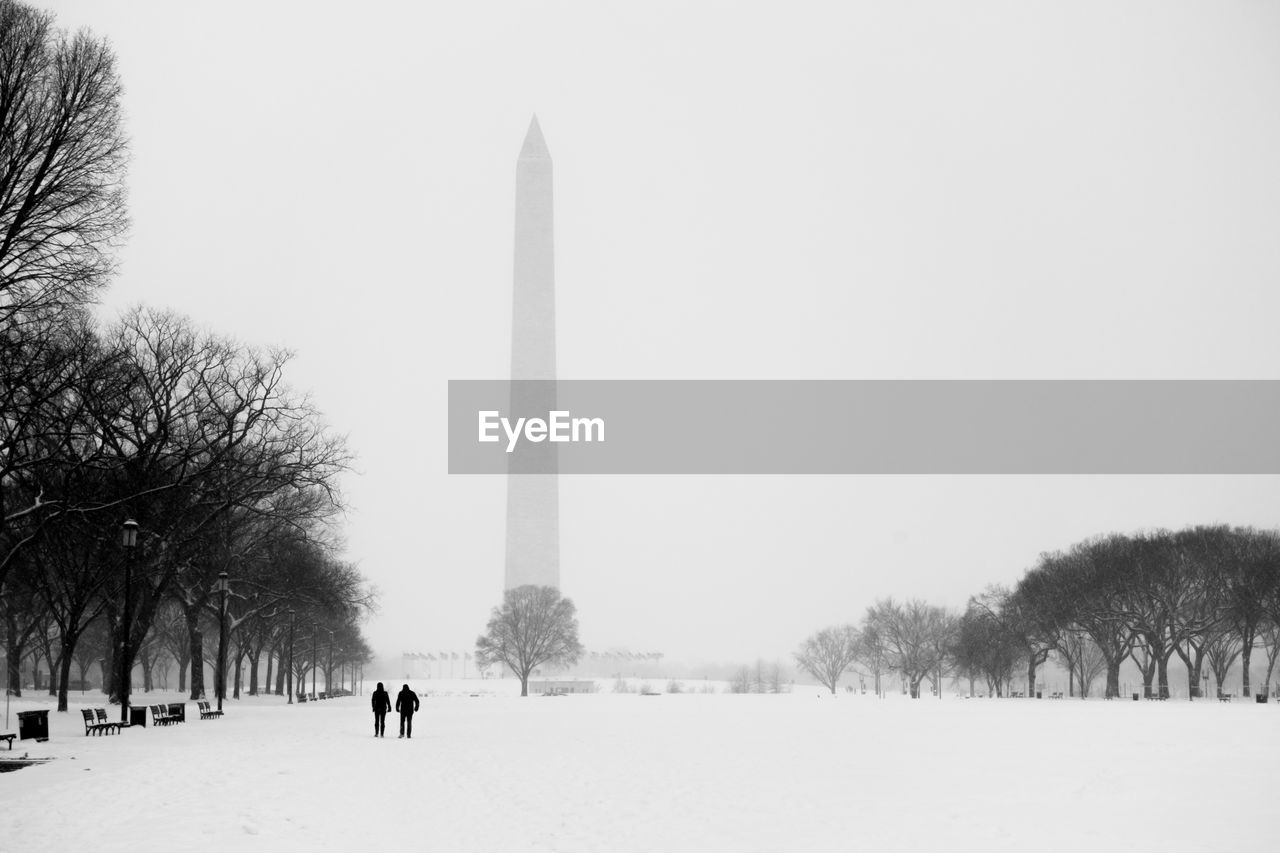 Snowcapped field against washington monument in foggy weather