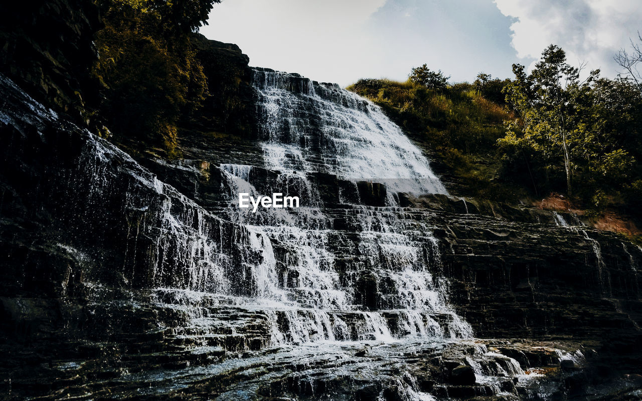 LOW ANGLE VIEW OF WATERFALL ON ROCK