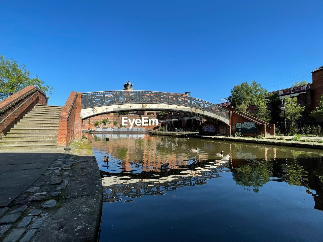 BRIDGE OVER CANAL AGAINST BLUE SKY