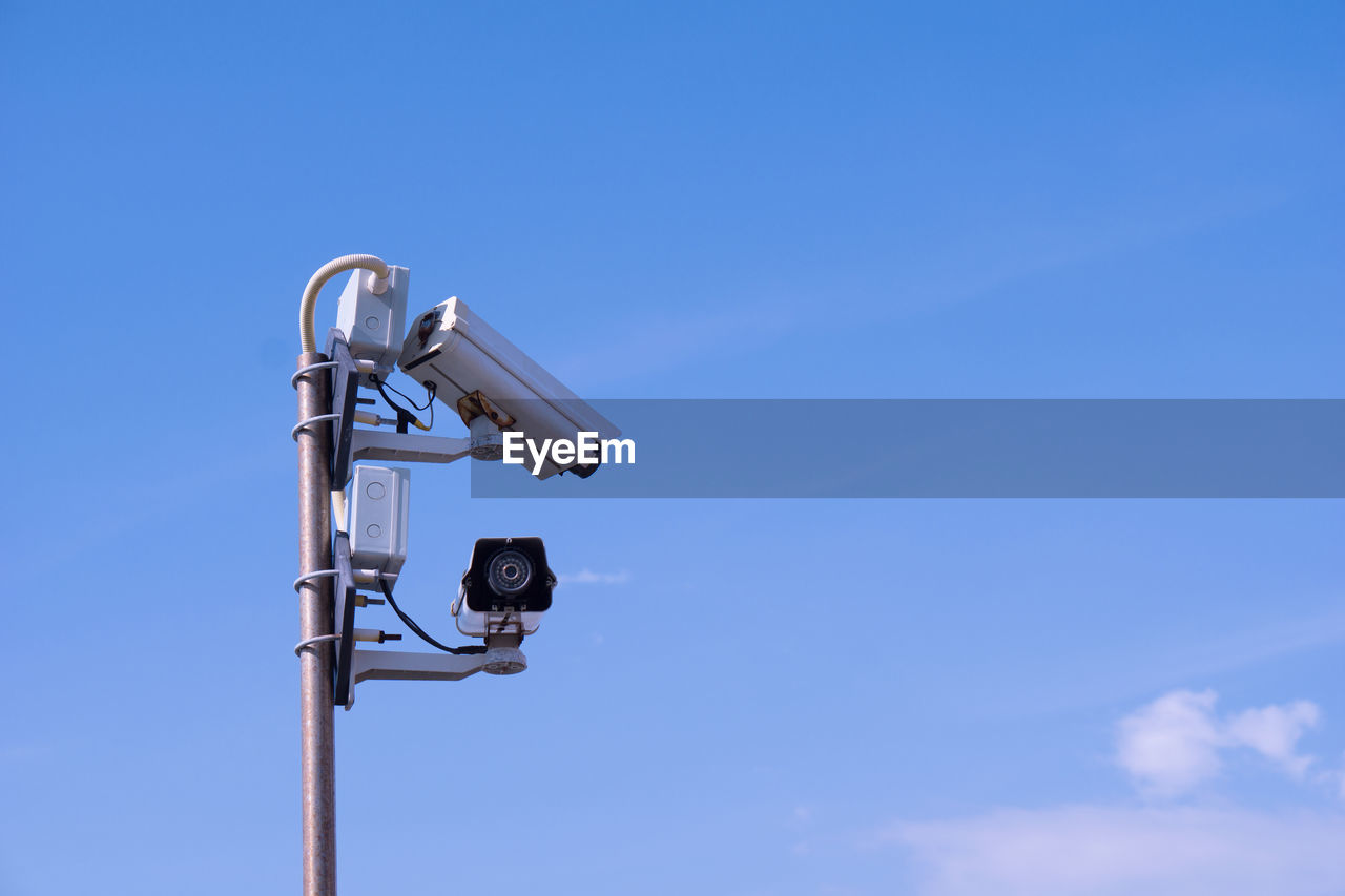 Low angle view of telephone pole against blue sky