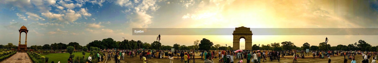 PANORAMIC VIEW OF CROWD IN FIELD AGAINST SKY