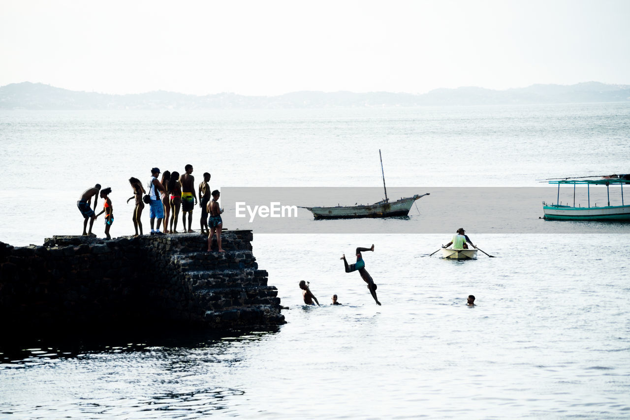 People are seen jumping from the porto da barra pier in the city of salvador, bahia.