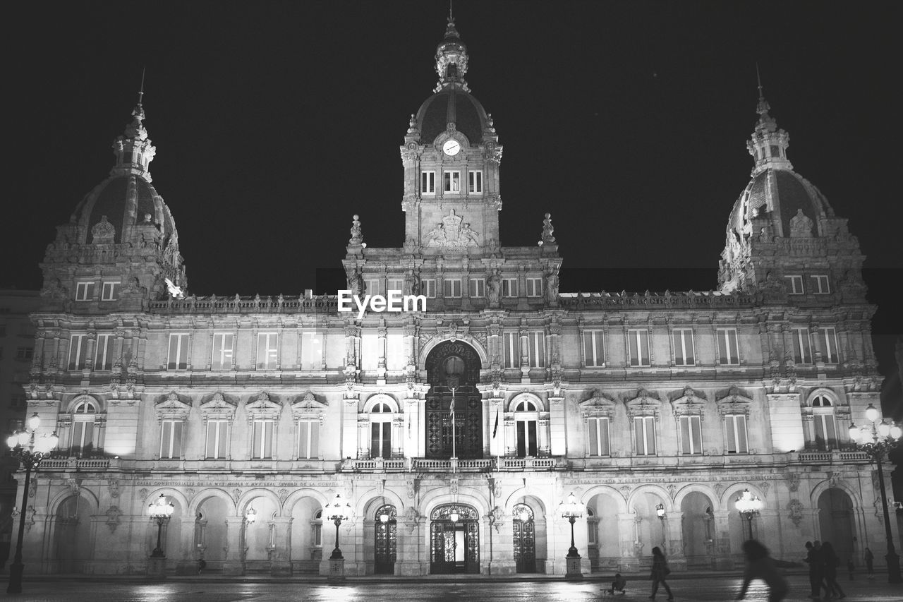 Facade of ayuntamiento de a coruna against sky at night