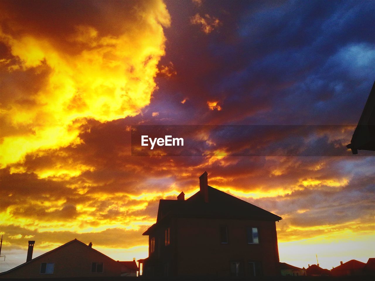 LOW ANGLE VIEW OF BUILDING AGAINST DRAMATIC SKY