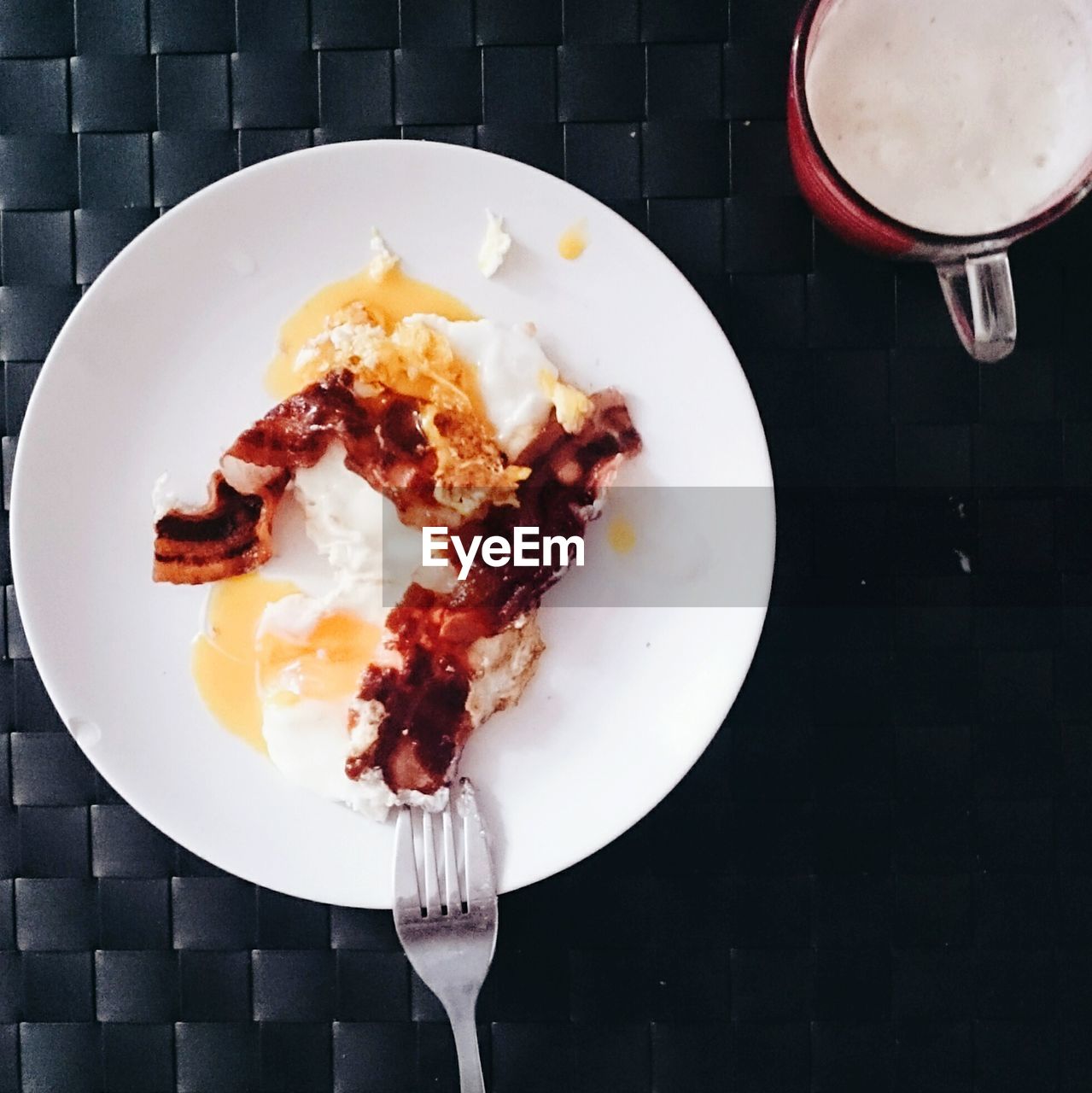 High angle view of egg served in plate by coffee cup on table