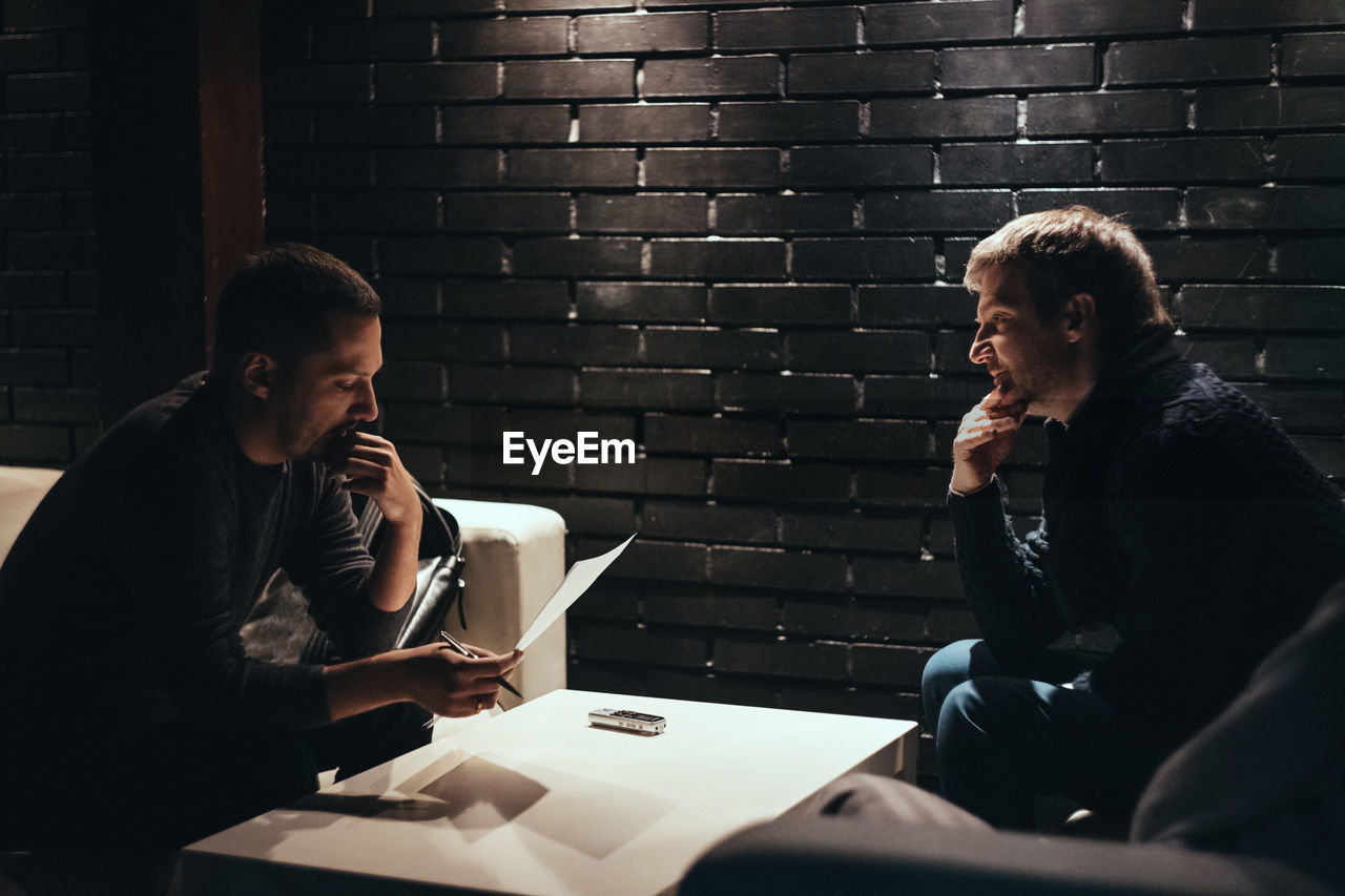 Men having discussion while sitting at table