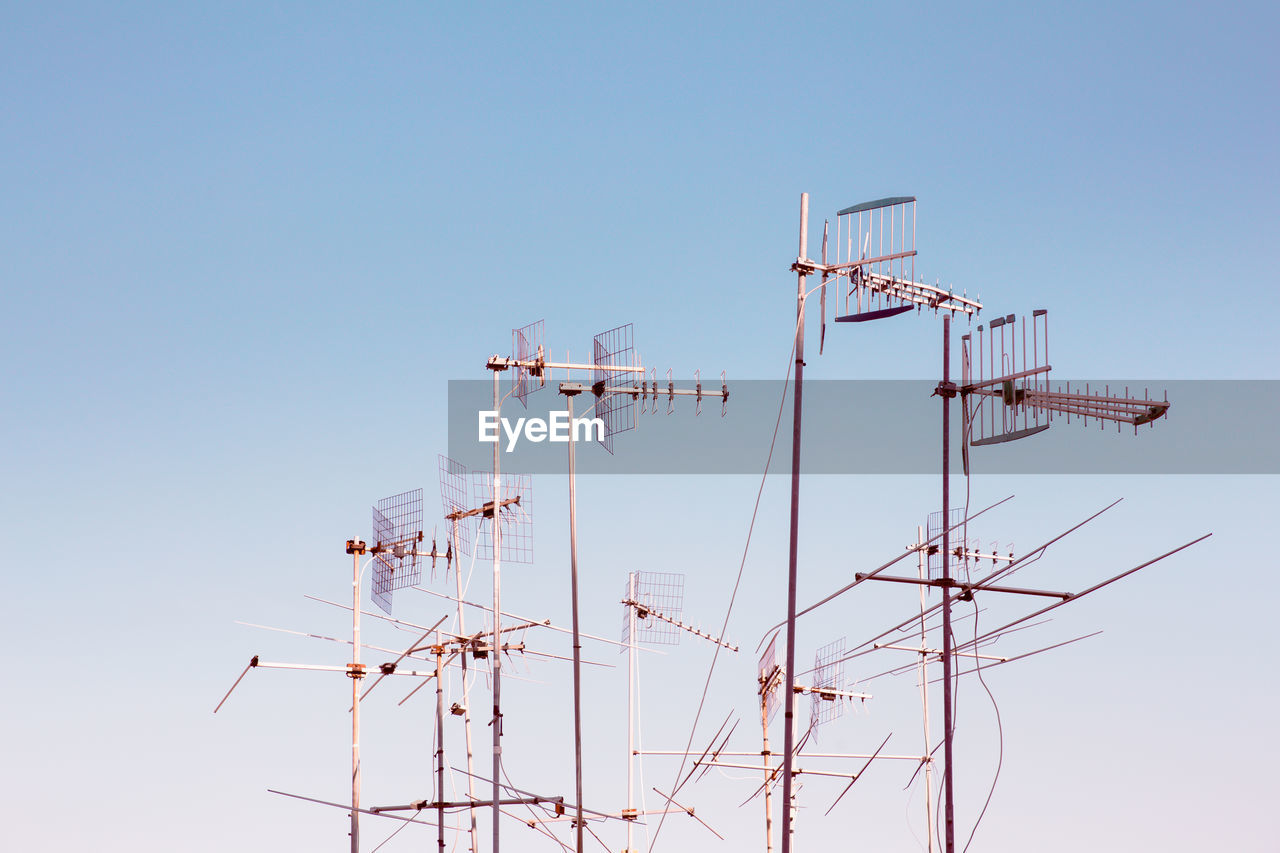 Low angle view of cranes against clear sky