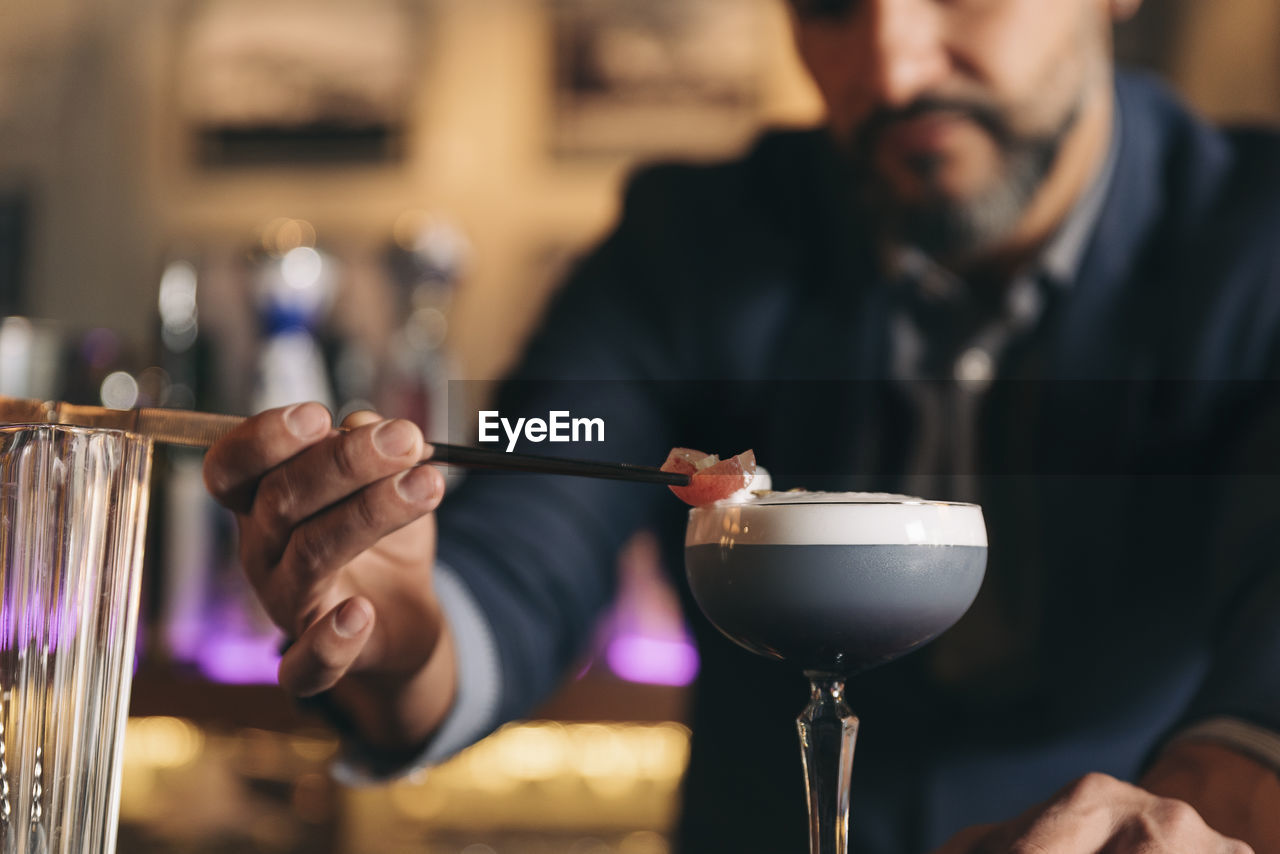 Male bartender preparing cocktail at bar counter