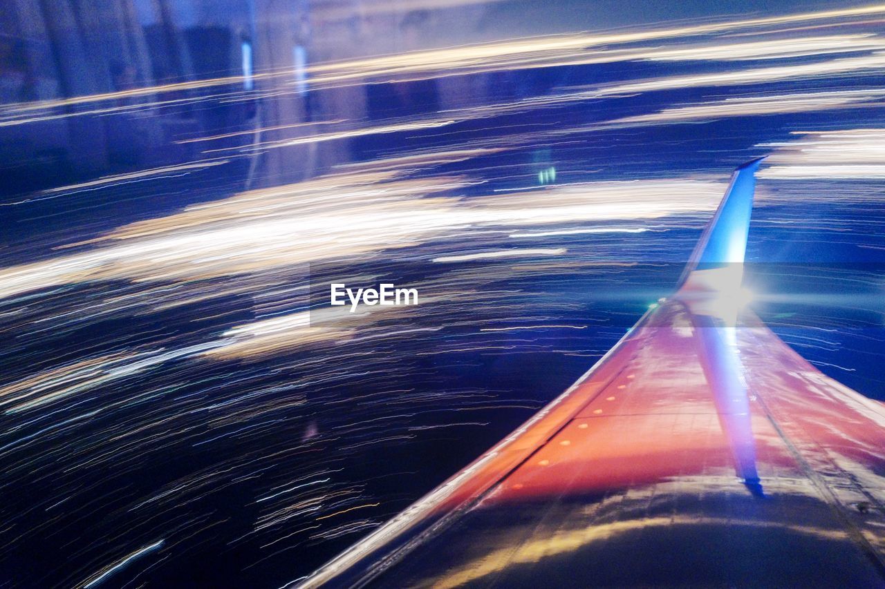 Airplane flying against light trails