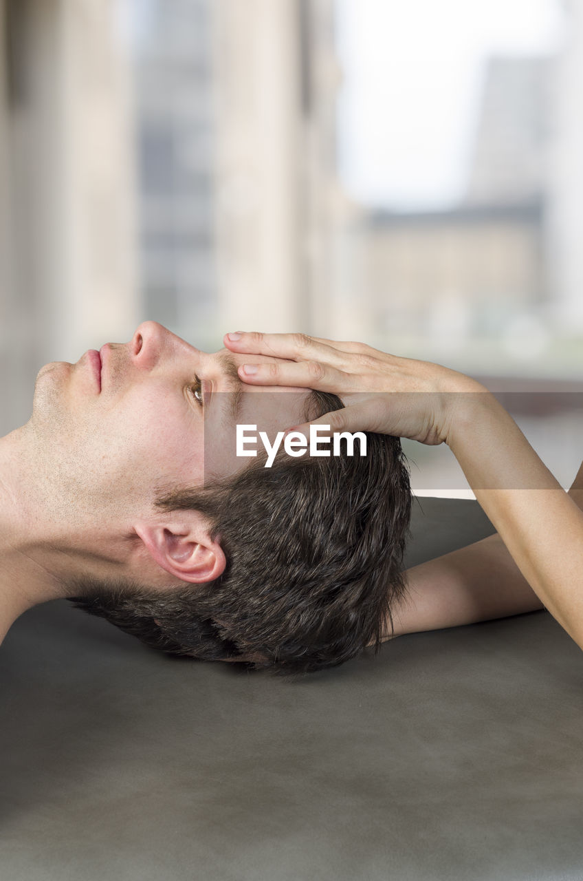 Cropped image of masseur massaging man in spa