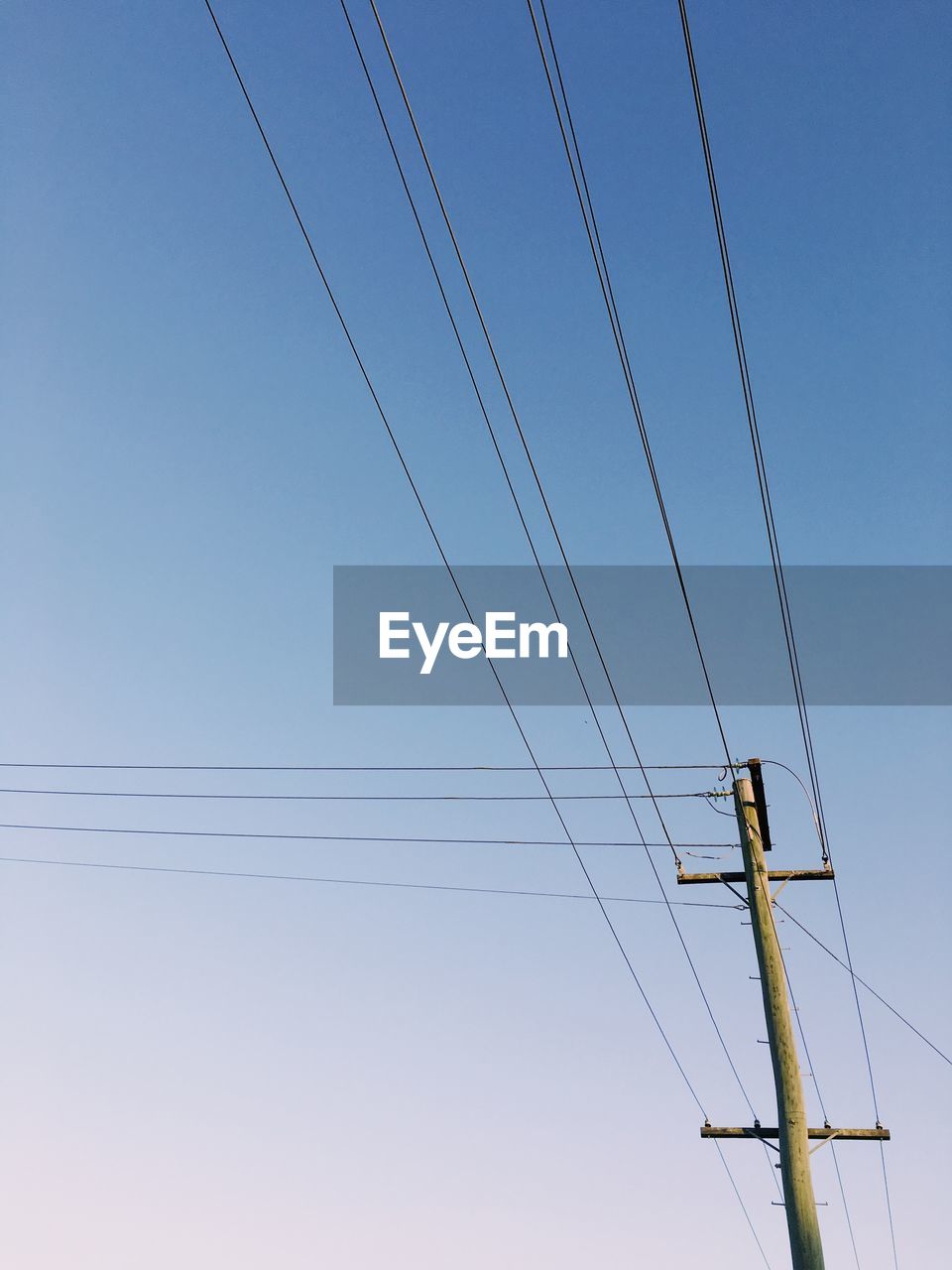 LOW ANGLE VIEW OF ELECTRICITY PYLON AGAINST CLEAR SKY