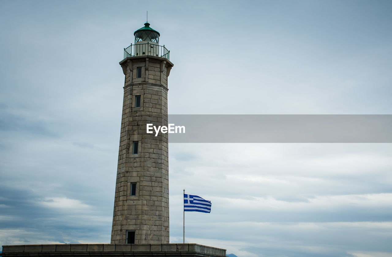 LOW ANGLE VIEW OF LIGHTHOUSE AGAINST BUILDING AND SKY