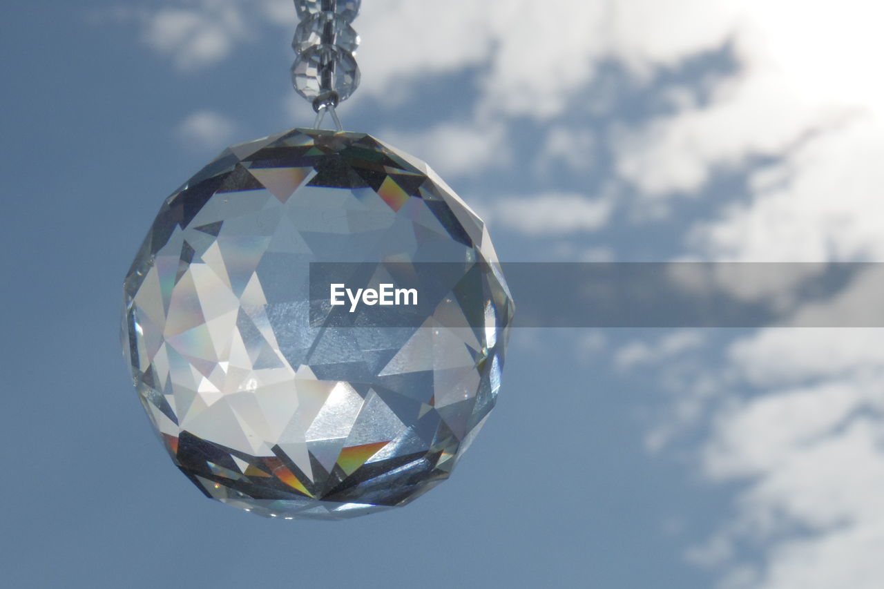 Low angle view of crystal ball decoration against sky