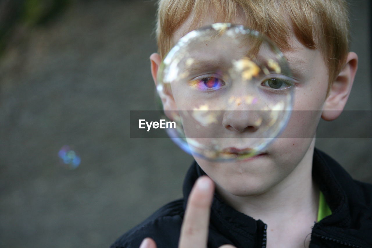 Close-up of boy looking at bubble