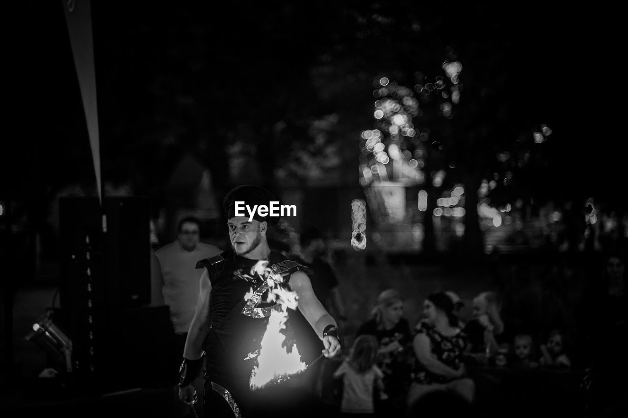 PORTRAIT OF WOMAN STANDING OUTDOORS AT NIGHT