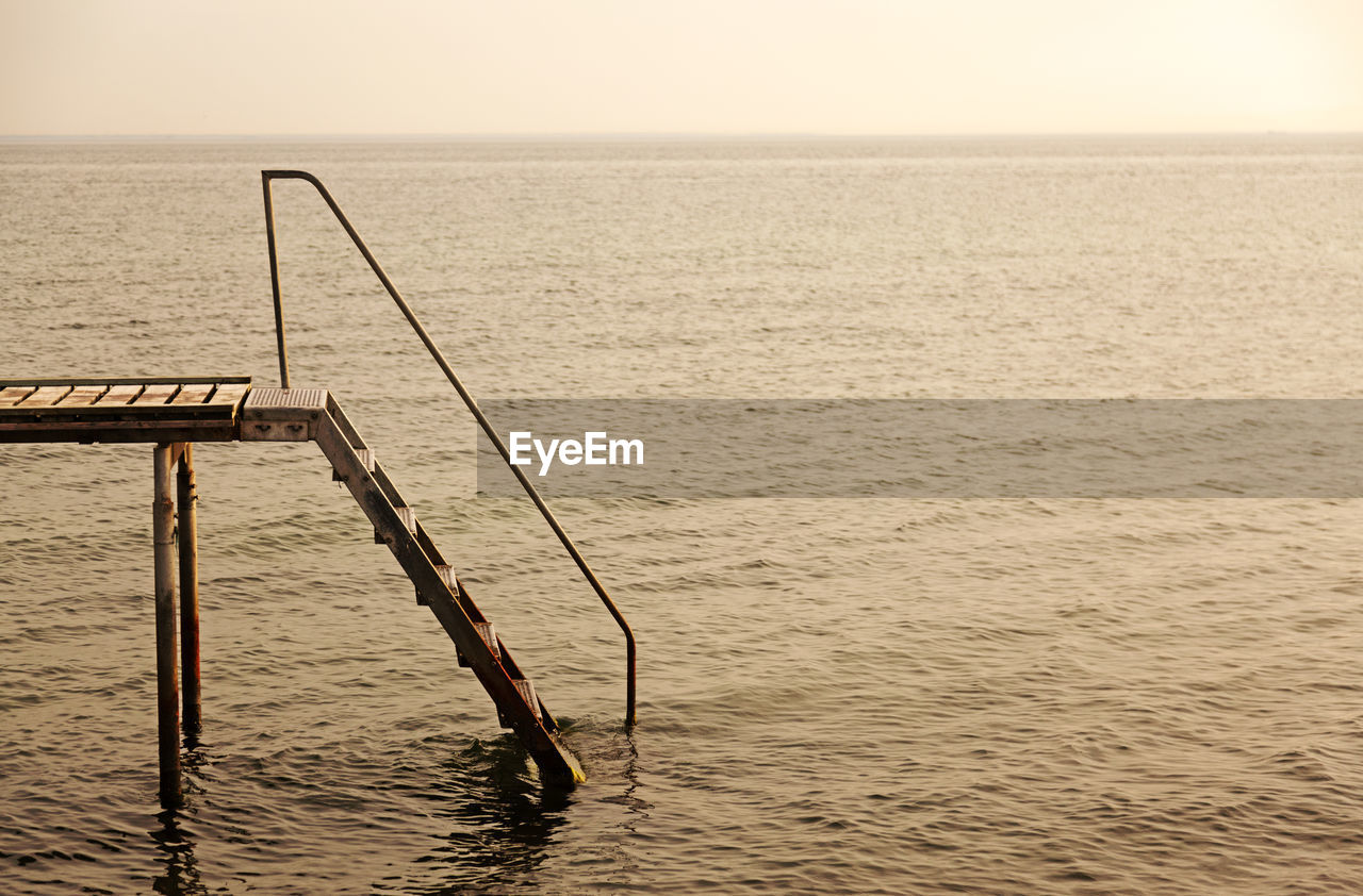 Sunset by the sea in denmark with a stair jetty in the foreground