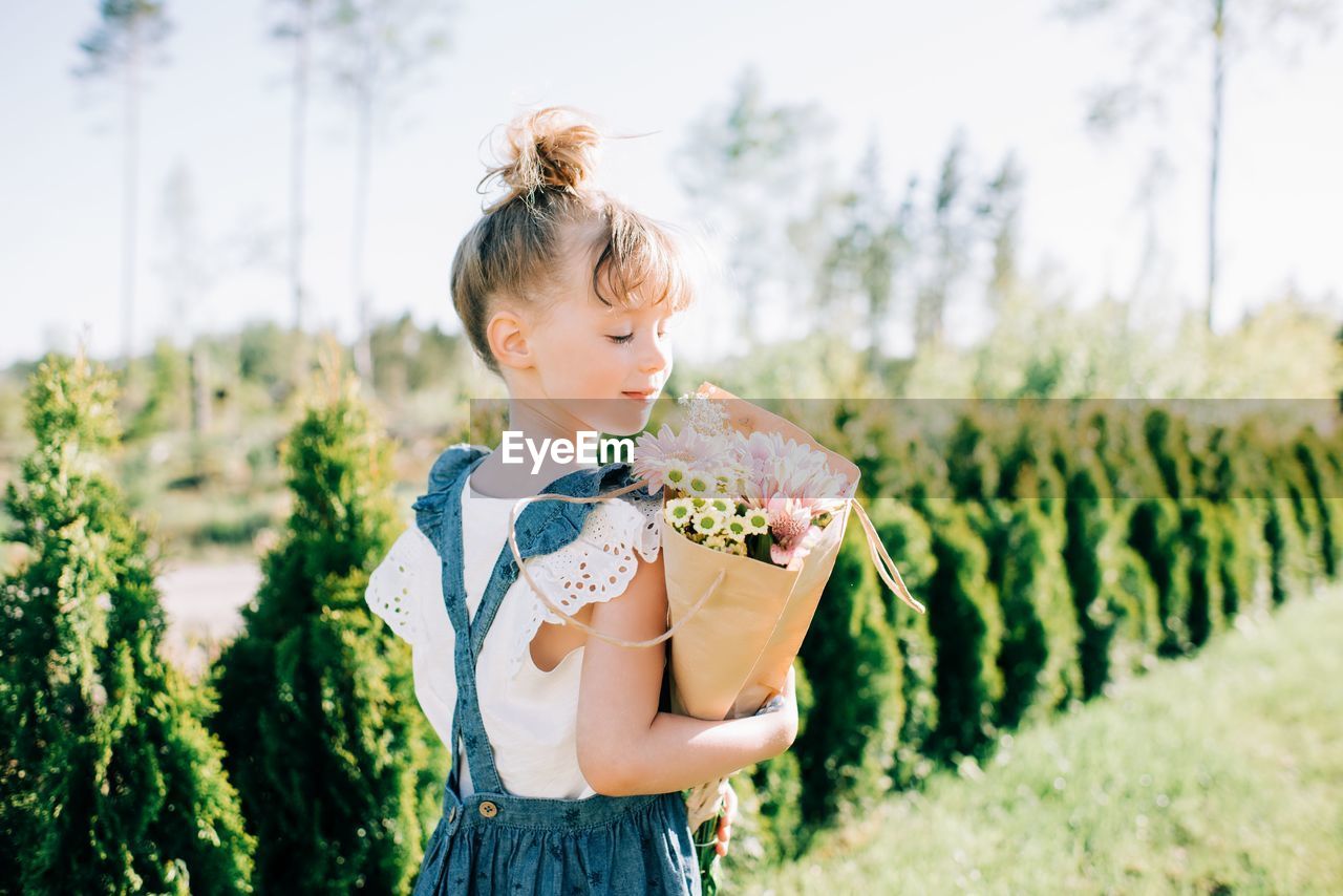 Portrait of a pretty young girl holding a beautiful bouquet of flowers