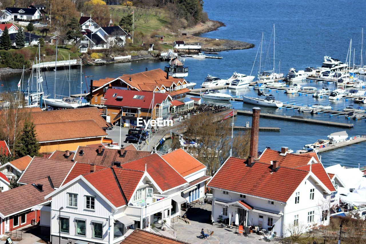 High angle view of houses by sea against sky