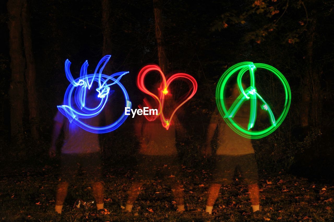 People drawing colorful light paintings