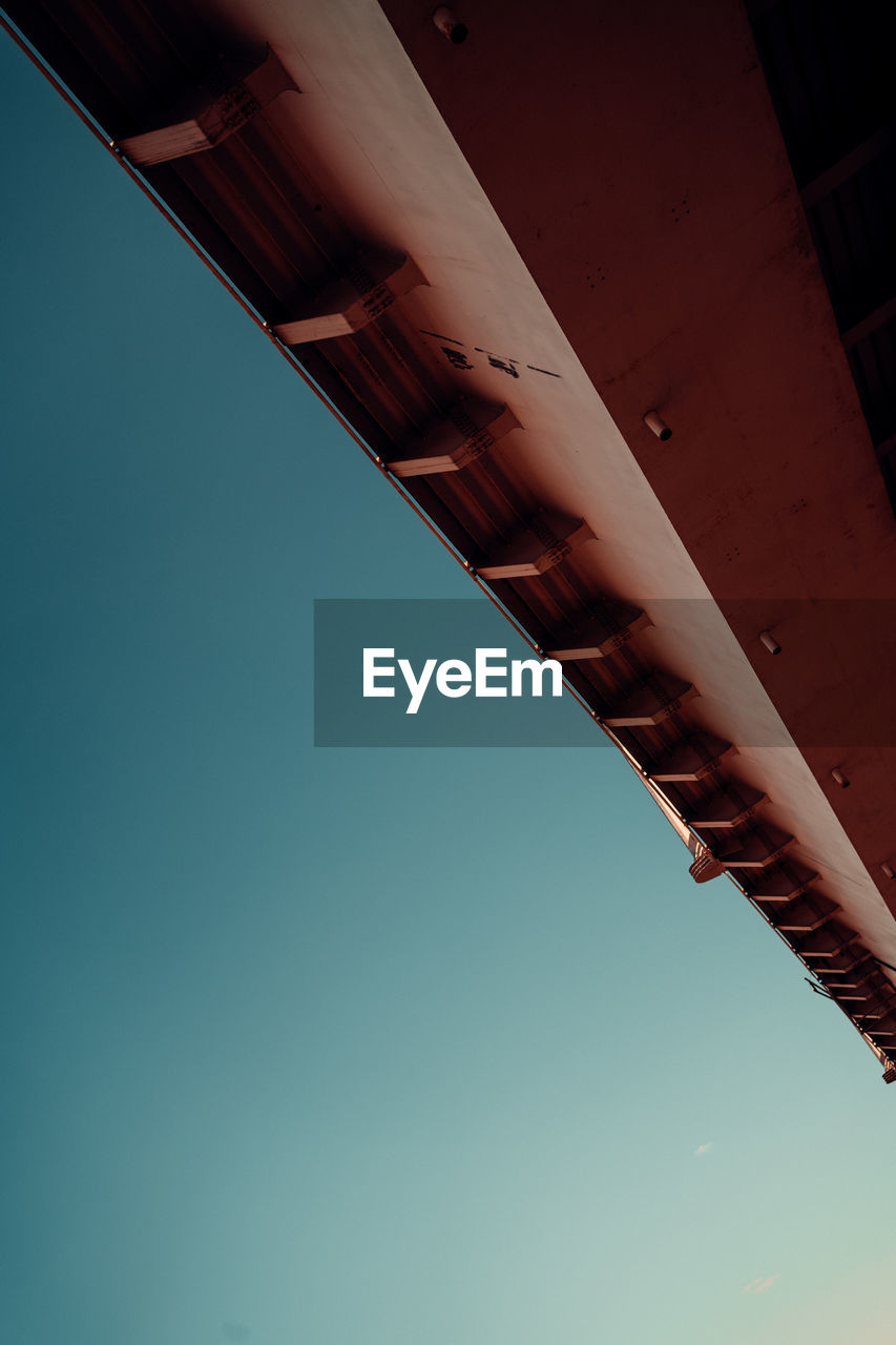 Low angle view of illuminated bridge against clear blue sky
