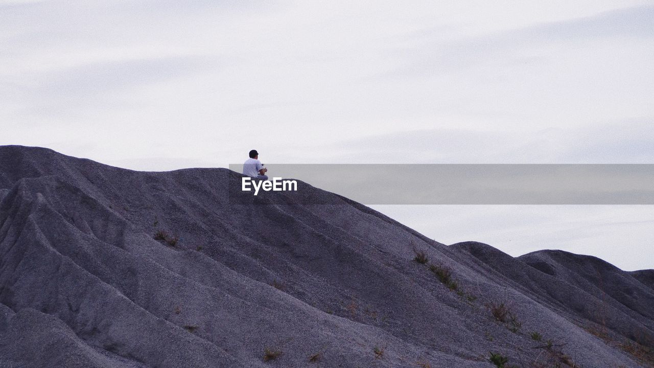 Low angle view of person on mountain against sky