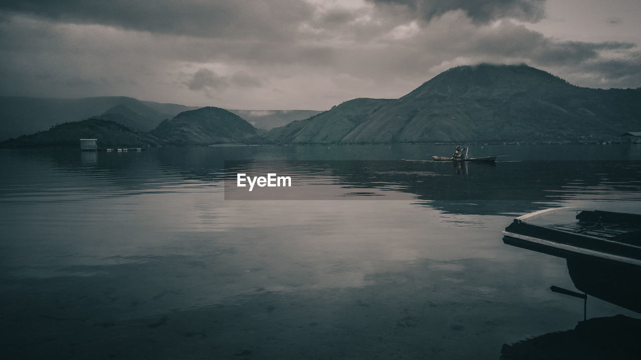 BOATS IN LAKE AGAINST SKY