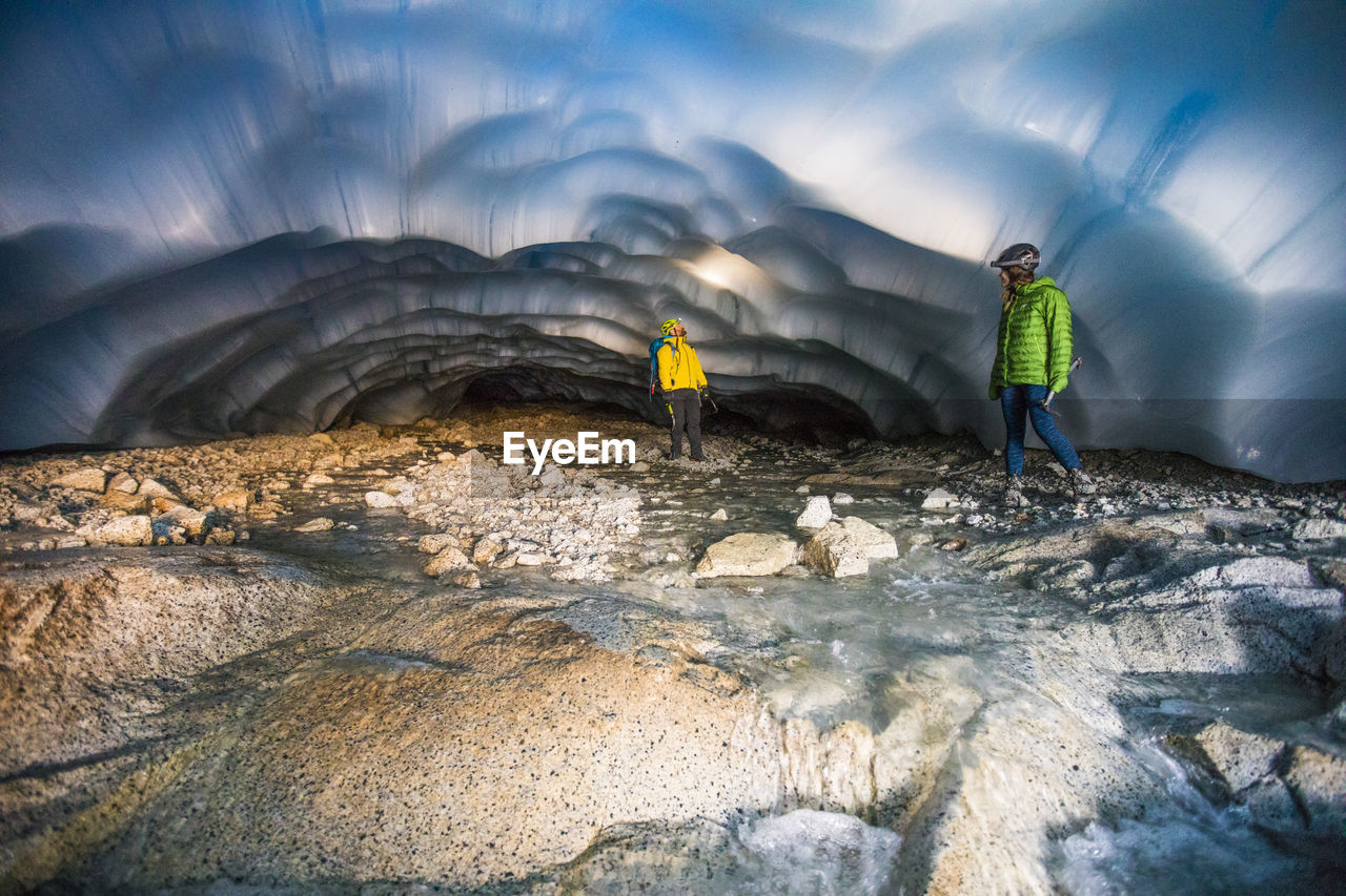 Adventurous couple exploring an ice cave.