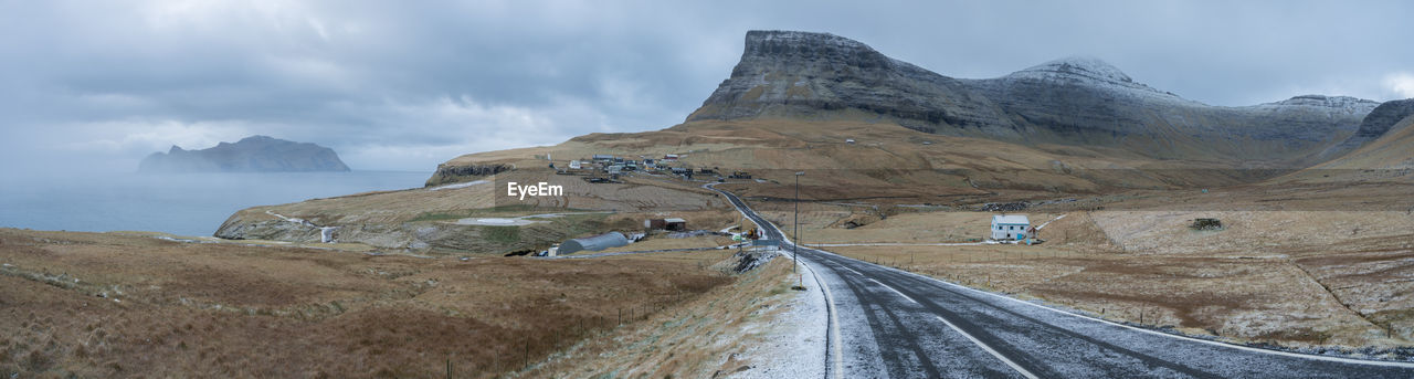 PANORAMIC VIEW OF ROAD BY MOUNTAIN AGAINST SKY