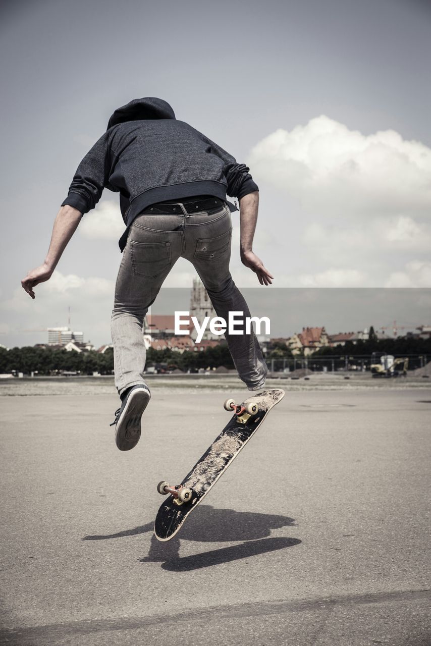 Rear view of man skateboarding on street