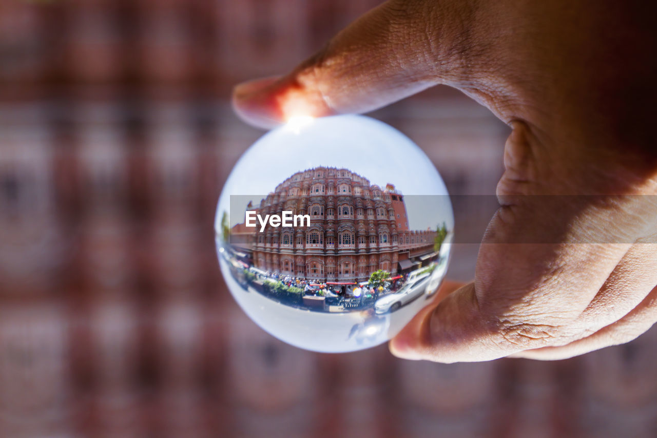 Cropped hand of person holding crystal ball