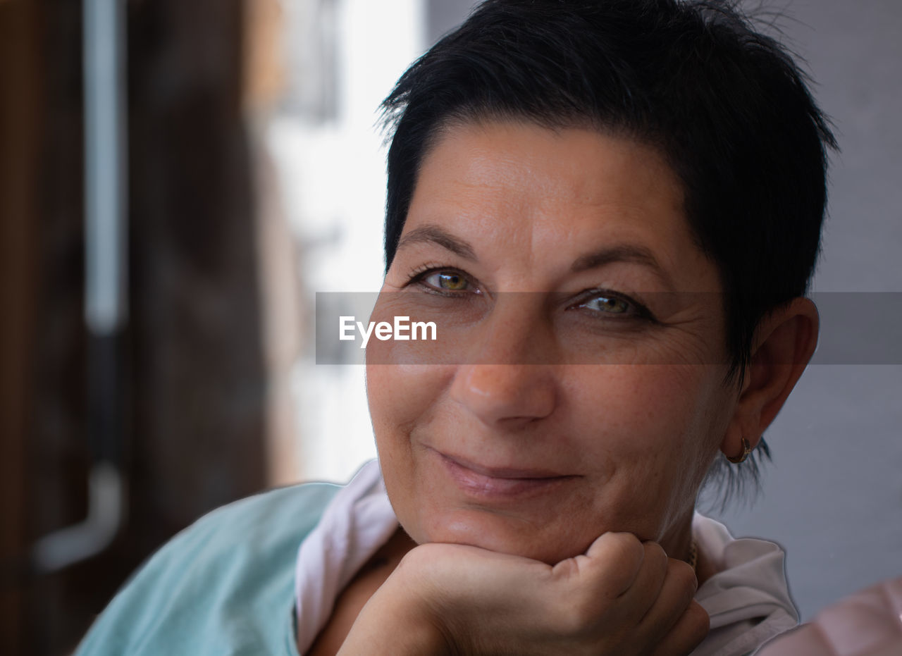 Close-up portrait of smiling woman at home