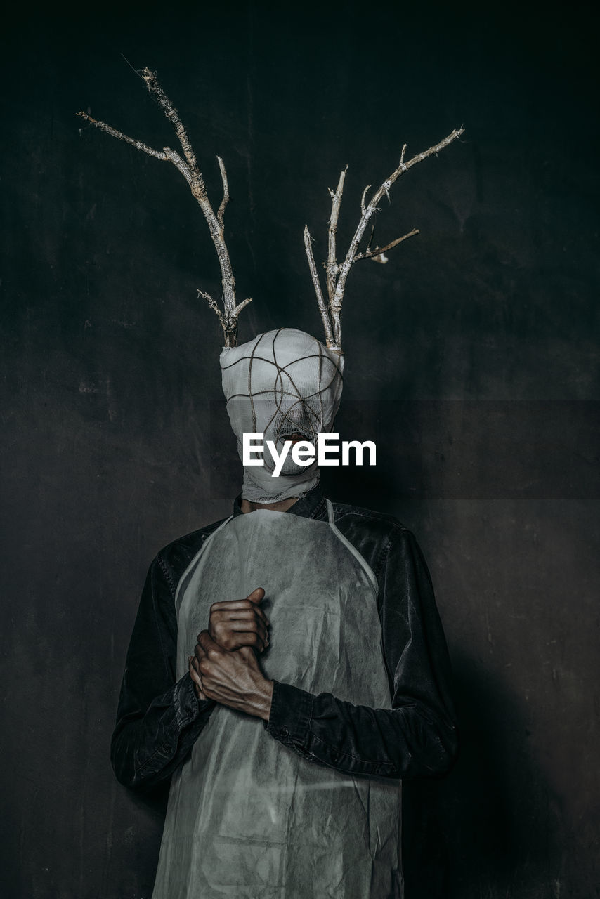 Portrait of person wearing mask standing at night