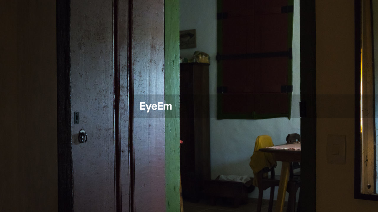 MAN LOOKING THROUGH WINDOW AT HOME