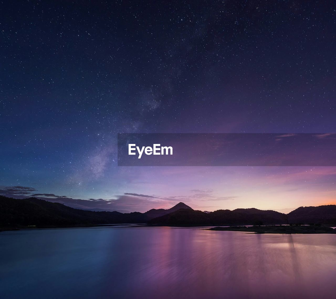 Long exposure shot of milky way over majestic mountain lake